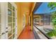 Covered porch with brick flooring and screened enclosure overlooks back yard and pool at 4647 Stone Ridge Trl, Sarasota, FL 34232