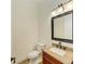 Stylish half-bath features a granite countertop and black framed mirror at 4647 Stone Ridge Trl, Sarasota, FL 34232
