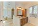 Bathroom featuring granite counters, wood cabinets, and a large framed mirror at 4647 Stone Ridge Trl, Sarasota, FL 34232