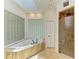 Bathroom featuring tub, skylight, glass block window, and a glass enclosed shower at 4647 Stone Ridge Trl, Sarasota, FL 34232
