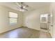 Light-filled bedroom with wood-look flooring, neutral walls, ceiling fan and ensuite bathroom access at 4647 Stone Ridge Trl, Sarasota, FL 34232