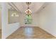 Bright dining room with tray ceilings and chandelier, complemented by a large arched window at 4647 Stone Ridge Trl, Sarasota, FL 34232