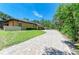Paver driveway leading to a three-car garage with solar panels and lush landscaping at 4647 Stone Ridge Trl, Sarasota, FL 34232
