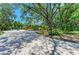 A paver driveway leads to a home surrounded by mature trees and lush landscaping at 4647 Stone Ridge Trl, Sarasota, FL 34232