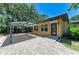 Home exterior featuring a paved patio, covered parking area, and well-maintained landscaping at 4647 Stone Ridge Trl, Sarasota, FL 34232