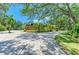 Home featuring mature palm trees, lush landscaping, and a paver driveway at 4647 Stone Ridge Trl, Sarasota, FL 34232