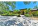 Stunning home featuring lush landscaping, mature trees, and a circular paver driveway at 4647 Stone Ridge Trl, Sarasota, FL 34232