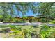 A home featuring lush landscaping, palm trees, and a long circular driveway at 4647 Stone Ridge Trl, Sarasota, FL 34232