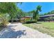 Home exterior featuring a paved patio, covered parking area, and well-maintained landscaping at 4647 Stone Ridge Trl, Sarasota, FL 34232