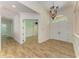 Welcoming foyer featuring double doors, wood-look tile flooring, and an elegant chandelier at 4647 Stone Ridge Trl, Sarasota, FL 34232