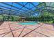 Screened in-ground pool with brick-paved patio and adjacent gazebo at 4647 Stone Ridge Trl, Sarasota, FL 34232