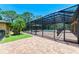 Screened-in pool area featuring brick pavers, a covered gazebo, and tropical landscaping at 4647 Stone Ridge Trl, Sarasota, FL 34232
