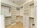 Bright walk-in closet features custom white shelving, drawers, and ample storage space at 4647 Stone Ridge Trl, Sarasota, FL 34232