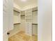 Bright walk-in closet features custom white shelving, drawers and ample storage space at 4647 Stone Ridge Trl, Sarasota, FL 34232
