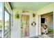 Inviting patio entrance with hanging plants, decorative accents, and views into the living room at 4727 Sabal Key Dr # 4727, Bradenton, FL 34203