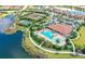 Stunning aerial view of the community clubhouse, pool, tennis courts, and surrounding landscape at 4809 Benito Ct, Bradenton, FL 34211