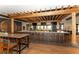 Stylish bar area with a wooden pergola, modern stools, and a well-stocked counter at 4809 Benito Ct, Bradenton, FL 34211