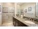 Bathroom featuring dual sinks, granite countertops, and a walk-in shower at 4809 Benito Ct, Bradenton, FL 34211