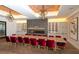 Elegant dining room with a large table, red velvet chairs, and modern lighting at 4809 Benito Ct, Bradenton, FL 34211