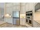 A modern kitchen boasts stainless steel appliances, granite countertops, tile backsplash, and white custom cabinets at 4809 Benito Ct, Bradenton, FL 34211