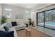 A modern living room features neutral paint, wood-look tile flooring, an outdoor view, and access to the lanai at 4809 Benito Ct, Bradenton, FL 34211