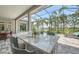An outdoor bar overlooks the pool and the lawn with a screened enclosure with palm trees in the background at 4809 Benito Ct, Bradenton, FL 34211