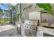 Close-up of a stainless steel grill and bar area in the outdoor kitchen with a built-in sink at 4809 Benito Ct, Bradenton, FL 34211