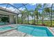 Beautiful screened-in pool with spa, lush landscaping, and a view of the golf course at 4809 Benito Ct, Bradenton, FL 34211