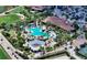 Aerial view of a community pool with palm trees, lounge chairs, and a clubhouse at 4809 Benito Ct, Bradenton, FL 34211