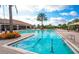 Beautiful community pool with lounge chairs and palm trees under a partly cloudy sky at 4809 Benito Ct, Bradenton, FL 34211