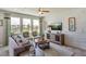 Comfortable living room with a plush sofa, stylish chairs, large windows, and tasteful decor at 5116 Rosado Run, Lakewood Ranch, FL 34211