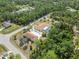 Aerial view of two homes in lushly landscaped neighborhood with mature trees and a shared screened pool at 5266 Wagon Wheel Dr, North Port, FL 34291