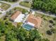 Aerial shot of home showing screened pool, detached garage, oversized driveway, and lush tropical landscaping at 5266 Wagon Wheel Dr, North Port, FL 34291