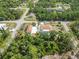 Aerial view showing home, screened pool, separate garage, oversized driveway, and lush tropical landscaping at 5266 Wagon Wheel Dr, North Port, FL 34291