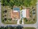 Overhead shot shows layout of home with screened pool, detached garage, long driveway, and lush tropical landscaping at 5266 Wagon Wheel Dr, North Port, FL 34291