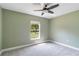 Bedroom with soft carpet, ceiling fan, and views of a leafy green yard at 5266 Wagon Wheel Dr, North Port, FL 34291
