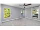 A spacious bedroom featuring a ceiling fan and natural lighting from the two windows overlooking the greenery at 5266 Wagon Wheel Dr, North Port, FL 34291