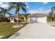 Lovely one-story home with a well-kept lawn, palm trees, and a large two-car garage with a long driveway at 5266 Wagon Wheel Dr, North Port, FL 34291