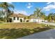 Attractive single-Gathering home boasting a manicured lawn, palm trees, and a lengthy driveway to its garages at 5266 Wagon Wheel Dr, North Port, FL 34291