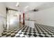 Bright open garage with checkered flooring, car lift, white walls, shelving, and roll up garage door at 5266 Wagon Wheel Dr, North Port, FL 34291