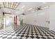 Bright and large garage with checkered flooring, car lift, ceiling fans, and block windows at 5266 Wagon Wheel Dr, North Port, FL 34291