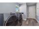 Laundry room with modern washer and dryer, wood-look floors, granite countertop and a window for natural lighting at 5266 Wagon Wheel Dr, North Port, FL 34291
