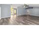 Open-concept living room with vaulted ceiling, fan, new gray wood floors and views to foyer at 5266 Wagon Wheel Dr, North Port, FL 34291