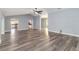 Large living area featuring new gray wood floors, light blue walls, and access to kitchen at 5266 Wagon Wheel Dr, North Port, FL 34291