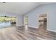 Bright living room featuring wood-look floors, pool view, and easy access to the kitchen at 5266 Wagon Wheel Dr, North Port, FL 34291