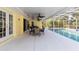 A covered patio next to a pool with an outdoor dining set and ceiling fans, perfect for entertaining or relaxation at 5266 Wagon Wheel Dr, North Port, FL 34291