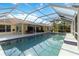 Spacious pool area with a screened enclosure, patio dining, outdoor seating, and views of the surrounding landscape at 5266 Wagon Wheel Dr, North Port, FL 34291