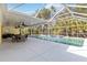 Covered patio next to a sparkling pool offering outdoor dining, with lush landscaping providing shade and privacy at 5266 Wagon Wheel Dr, North Port, FL 34291