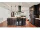 Kitchen island with stovetop, dark cabinets, hardwood floor, and open layout into the living area at 532 Oak Hill Cir # 12, Sarasota, FL 34232