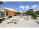 Outdoor patio area with tables, chairs, and sunshade overlooking a tranquil lake with surrounding greenery at 532 Oak Hill Cir # 12, Sarasota, FL 34232
